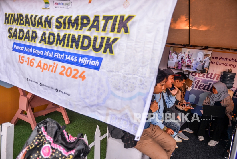 Petugas Disdukcapil Kota Bandung melakukan pencatatan kependudukan kepada penumpang yang baru turun dari bus di Terminal Cicaheum, Bandung, Jawa Barat, Selasa (16/4/2024). 