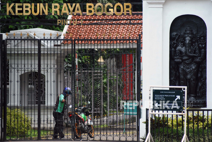 Pengemudi ojek daring berada di area pintu masuk Kebun Raya Bogor yang ditutup untuk umum di Kota Bogor, Jawa Barat, Kamis (19/3/2020). 
