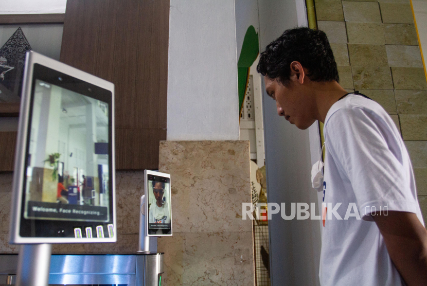 Calon penumpang melakukan scan wajah di Stasiun Yogyakarta, Senin (3/4/2023). PT Kereta Api Indonesia melakukan peningkatan layanan dengan menerapkan teknologi 