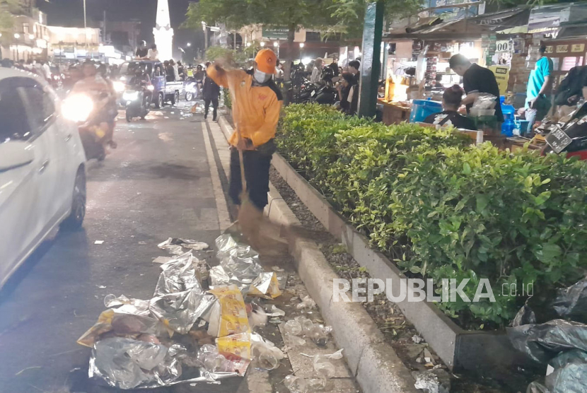 Petugas kebersihan menyapu sampah-sampah usai perayaan Tahun Baru 2024 di kawasan Tugu Pal Putih, Kota Yogyakarta, Senin (1/1/2024).