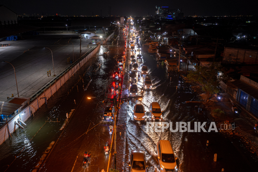 Foto udara sejumlah kendaraan melintasi jalur utama pantura Demak-Semarang yang tergenang banjir rob di Kecamatan Sayung, Kabupaten Demak, Jawa Tengah, Ahad (7/4/2024). 