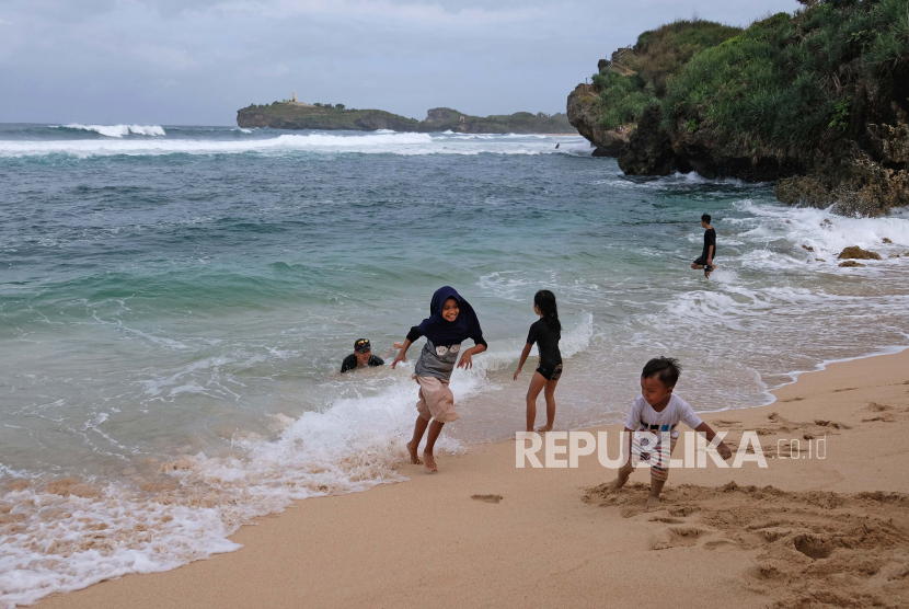 Wisatawan bermain di pantai Sadranan Dusun Pulegundes, Sidoharjo, Tepus, Gunungkidul, DI Yogyakarta. (ilustrasi)