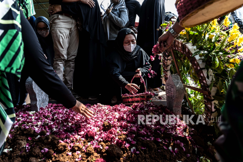Istri almarhum Lettu Wisnu Tia Aruni, Yuanita Rahmawati menabur bunga pada pusara suaminya usai prosesi pemakaman di Tempat Pemakaman Umum Kembangarum (Bergota II), Semarang, Jawa Tengah, Ahad (7/6/2020). Lettu Wisnu Tia Aruni merupakan satu dari empat prajurit TNI AD yang tewas dalam insiden kecelakaan helikopter MI-17 V5 di Kawasan Industri Kendal (KIK), Jateng pada Sabtu (6/6/2020)