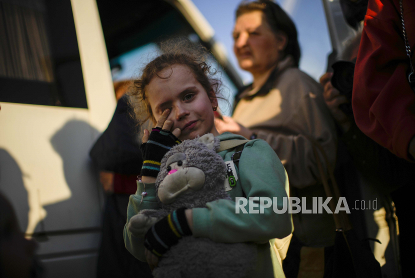 Seorang anak dan keluarganya yang melarikan diri dari Mariupol tiba di pusat penerimaan pengungsi di Zaporizhzhia, Ukraina, Minggu, 8 Mei 2022. 
