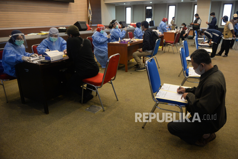 Petugas kesehatan mengambil sampel darah anggota Panitia Pemungutan Suara (PPS) dan panitia pemilihan kecamatan (PPK) saat mengikuti rapid test.