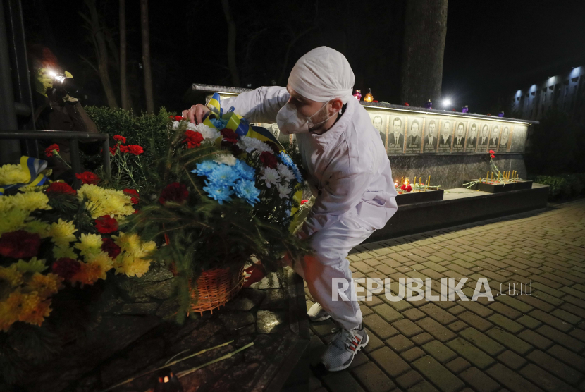 Seorang pria berpakaian kostum pekerja pabrik nuklir meletakkan bunga di monumen peringatan yang meninggal selama pembersihan setelah bencana pembangkit listrik tenaga nuklir Chernobyl ketika upacara di kota Slavutich, sekitar 190 km utara ibukota Kiev, Ukraina, Ahad (26/4). Pada dini hari tanggal 26 April 1986, reaktor unit 4 di pembangkit listrik Chernobyl pecah