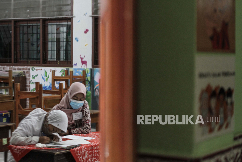 Guru mendampingi siswa berkebutuhan khusus saat pelaksaan Asesmen Standarisasi Pendidikan Daerah (ASPD) di SD N Giwangan, Umbulharjo, Yogyakarta.