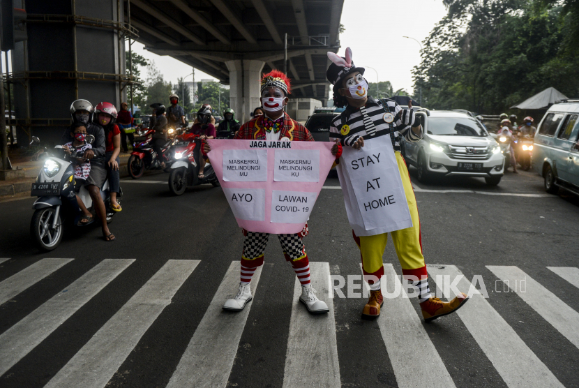 Seniman yang tergabung dalam Aku Badut Indonesia (ABI) saat melakukan kampanye pencegahan penyebaran virus Corona (Covid-19) di kawasan Pasar Rebo, Jakarta, Sabtu (18/4). Kampanye tersebut sebagai bentuk kepedulian ABI terhadap pandemi Corona yang belum juga mereda