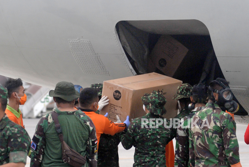 Petugas memindahkan Alat Pelindung Diri (APD) dari pesawat B737-400 milik TNI AU di Bandara I Gusti Ngurah Rai, Bali, Senin (23/3/2020). 