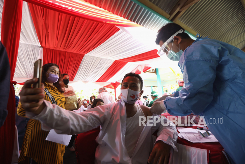 Warga berswafoto saat mendapatkan suntikan vaksinasi booster COVID-19 di Balai Desa Pakistaji, Banyuwangi, Jawa Timur, Rabu (19/1/2022). Pemberian vaksinasi dosis lanjutan atau booster dibutuhkan guna meningkatkan proteksi individu dan memperbaiki efektivitas vaksin. 