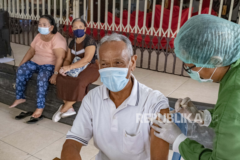  Seorang pria menerima suntikan vaksin COVID-19 saat kampanye vaksinasi COVID-19 massal untuk lansia di Denpasar, Bali, Indonesia, 06 April 2021. 