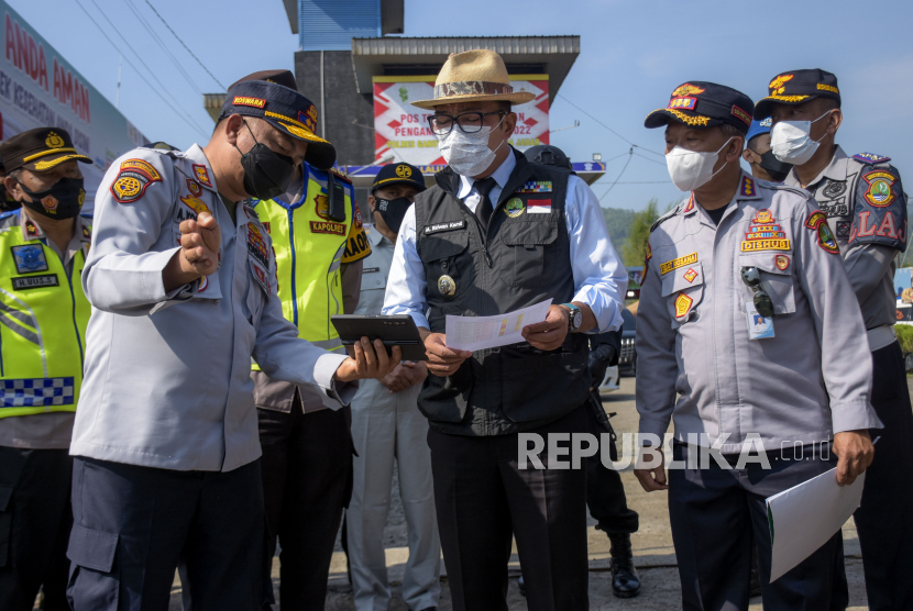 Gubernur Jawa Barat Ridwan Kamil (tengah) mendengarkan pemaparan dari Kadishub Provinsi Jawa Barat A Koswara Hanafi (kiri) saat meninjau Pos Terpadu Limbangan di Limbangan, Kabupaten Garut. 
