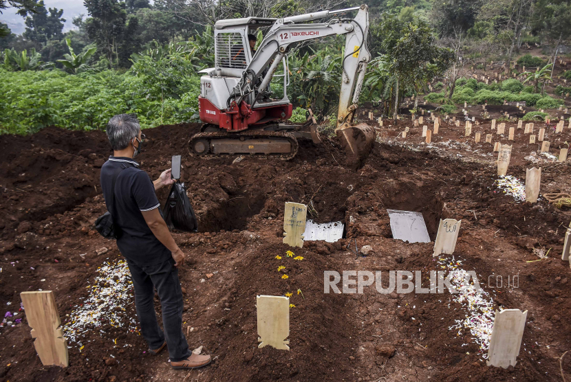 Kerabat melihat prosesi pemakaman dengan protokol Covid-19 di TPU Cikadut, Jalan Cikadut, Mandalajati, Kota Bandung. Berdasarkan hasil data yang dihimpun Jawa Barat menjadi kontributor tertinggi yang menambahkan 180 kasus kematian.