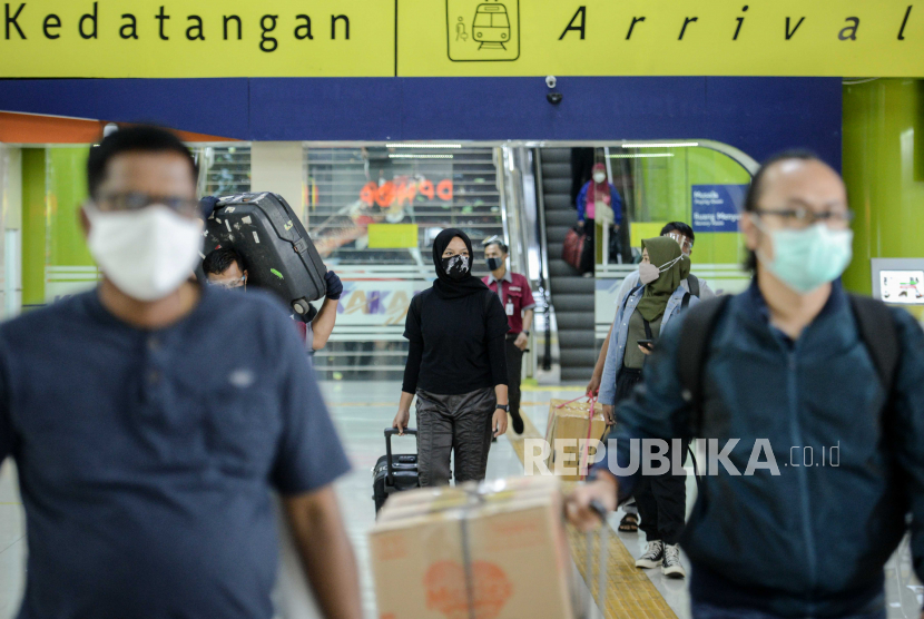 Penumpang berjalan usai tiba di Stasiun Gambir, Jakarta, Senin (16/11).