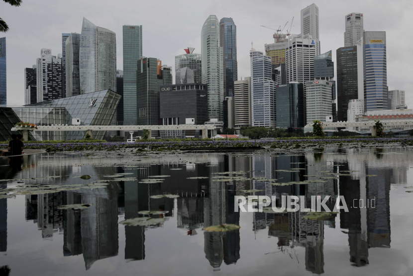  Cakrawala distrik keuangan tercermin dalam kolam teratai di sebelah ArtScience Museum di Singapura, 14 Juli 2020. Ekonomi Singapura menyusut rekor 41,2 persen sebagai akibat dari langkah-langkah pemutus sirkuit yang diterapkan antara April dan Mei 2020 untuk membendung penyebaran COVID -19. Perkiraan kontraksi antara empat dan tujuh persen akan menjadikan resesi yang pertama sejak 2009, dan yang terburuk sejak Singapura merdeka pada 1965.