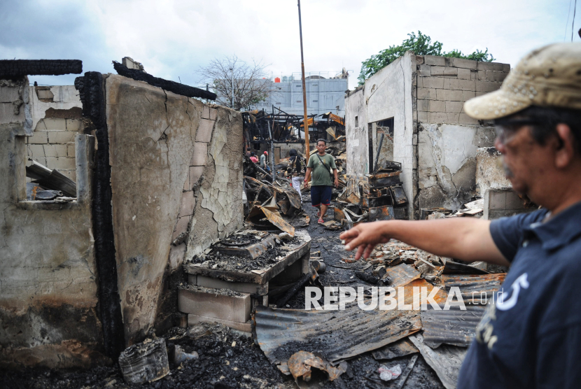 Sejumlah warga melihat rumahnya yang terbakar di lokasi kebakaran permukiman padat penduduk di Jalan Kemayoran Gempol, Kebon Kosong, Kemayoran, Jakarta, Selasa (21/1/2025). Kebakaran besar yang terjadi pada dini hari tersebut menghanguskan 543 rumah yang berdampak  terhadap 1.797 jiwa atau 607 kepala keluarga (KK). Sebanyak 34 unit mobil pemadam dengan 170 personel dikerahkan untuk menangani kebakaran tersebut. Upaya pemadaman dimulai sekitar pukul 01.22 WIB dan proses pendinginan dimulai pada pukul 06.00 WIB.