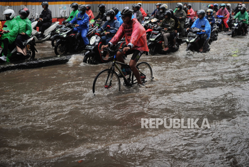 Pesepeda melewati genangan air (Foto: ilustrasi)