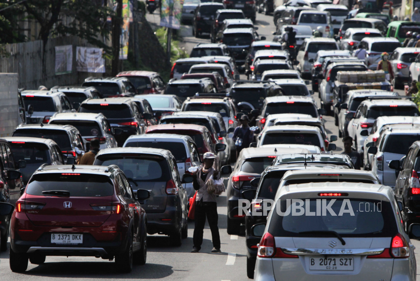 Pedagang berjualan di dekat antrean kendaraan di Bogor. Pemkot Bogor menerapkan kebijakan 4 in 1 untuk ASN dalam menekan polusi udara.
