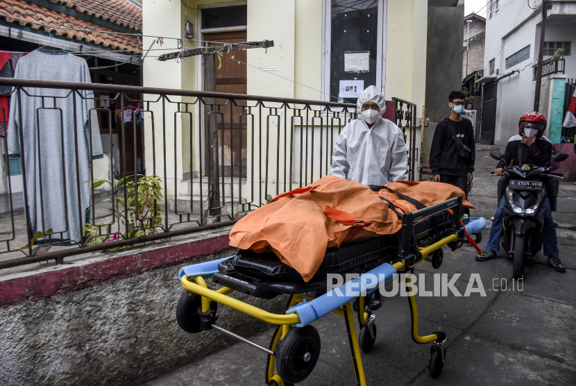 Petugas Public Safety Center 119 (PSC 119) bersama warga mengevakuasi jenazah menggunakan prosedur tetap (Protap) Covid-19 di Jalan Pasir Kaliki Tengah, Coblong, Kota Bandung, Kamis (5/8). Data dari Public Safety Center 119 selama penerapan PPKM Level 4 di Kota Bandung, pelayanan serta penanganan kasus Covid-19 yang ditangani cenderung menurun atau hanya 5 kasus per hari dibandingkan dengan bulan lalu yang bisa mencapai 30 kasus per hari. Sementara data dari situs covid19.bandung.go.id hingga (4/8) pukul 19.05 WIB, tercatat kasus terkonfirmasi Covid-19 sudah mencapai 38.318 kasus dan angka kematian akibat Covid-19 sebanyak 1.286 kasus sementara jumlah pasien yang dinyatakan sembuh sebanyak 30.181 kasus. Foto: Republika/Abdan Syakura