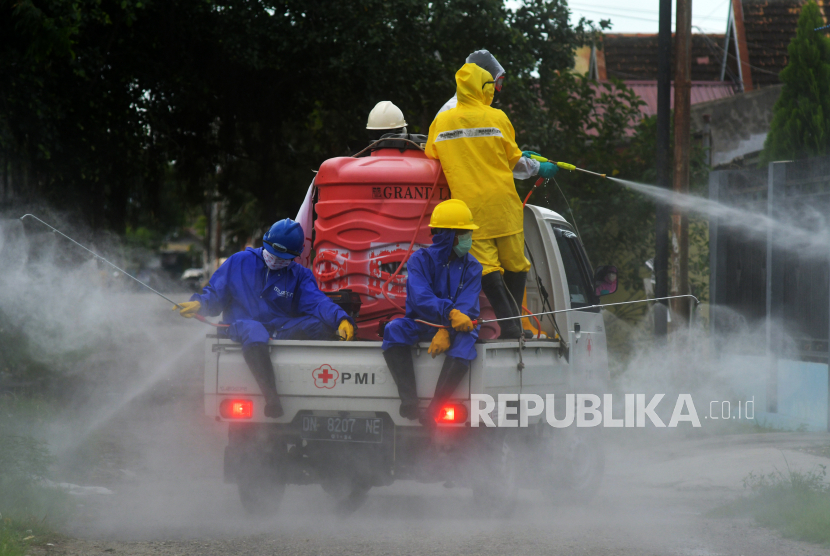 Petugas PMI menyemprotkan cairan disinfektan di sekitar pemukiman warga (ilustrasi)