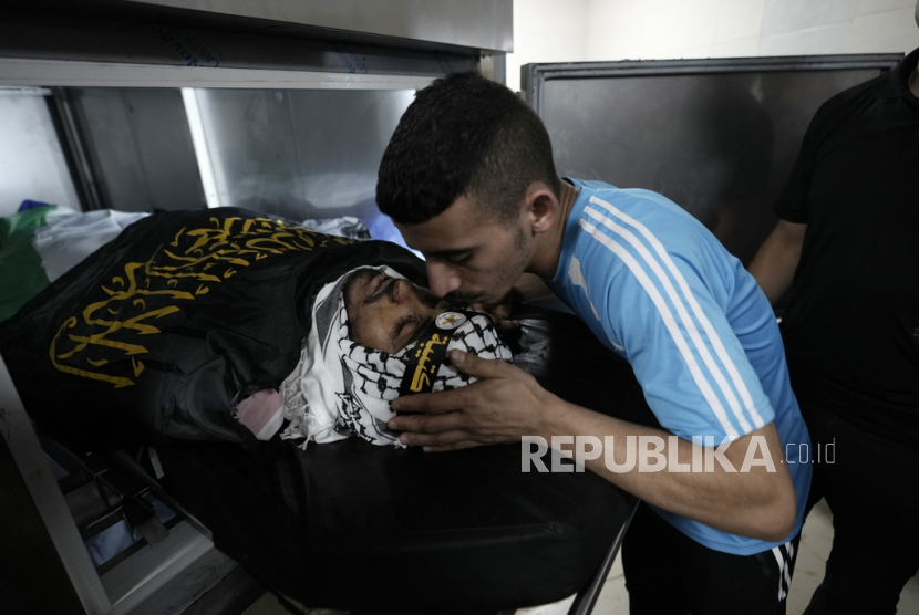 Sejumlah ayat Alquran kerap dipakai Israel saat menyerang Palestina. Foto:   Seorang pelayat mencium jenazah Khaled Asaasa, salah satu dari beberapa warga Palestina yang meninggal.