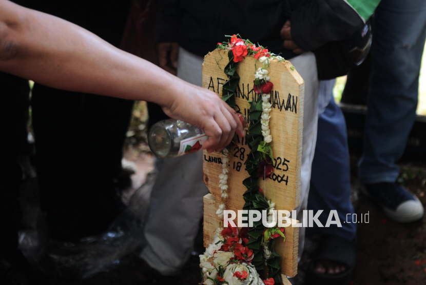 Para kerabat menaburkan bunga di makam Affan Kurniawan (21) di TPU Karet Bivak, Jakarta, Jumat (29/8/2025).