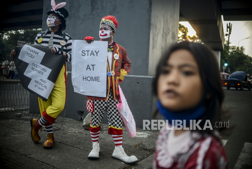 Seniman yang tergabung dalam Aku Badut Indonesia (ABI) saat melakukan kampanye pencegahan penyebaran virus Corona (Covid-19) di kawasan Pasar Rebo, Jakarta, Sabtu (18/4). Kampanye tersebut sebagai bentuk kepedulian ABI terhadap pandemi Corona yang belum juga mereda