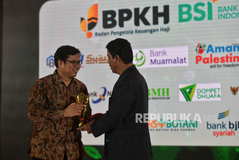 Direktur Utama PT Bank Muamalat Indonesia Tbk Indra Falatehan (kiri) menerima Anugerah Syariah Republika 2023 dari Pemimpin Redaksi Republika Elba Damnhuri di Jakarta, Kamis (30/11/2023).