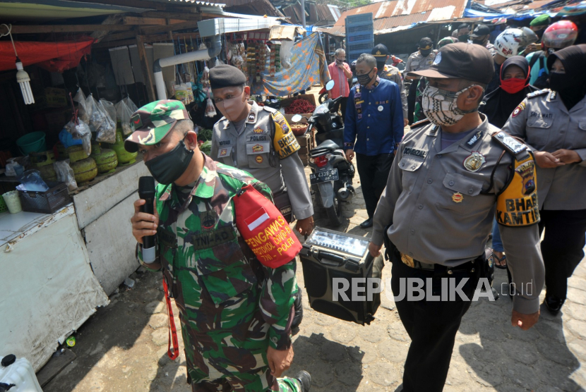 Personel kepolisian dan TNI menyosialisasikan penggunaan masker di Pasar Simpang Haru Padang, Sumatera Barat, Kamis (3/9/2020). TNI dan Polri serta pihak terkait terus menyosialisasikan penggunaan masker dan imbauan jaga jarak kepada warga di tempat keramaian menyusul kasus COVID-19 yang terus meningkat. 