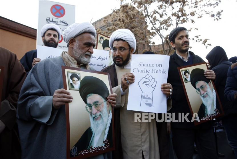  Ulama Iran memegang foto pemimpin tertinggi Iran Ayatollah Ali Khamenei selama demonstrasi protes anti-Prancis di depan kedutaan Prancis di Teheran, Iran, Ahad (8/1/2023). Iran mengutuk keras penerbitan kartun yang menggambarkan pemimpin tertinggi Iran Aayatollah Ali Khamenei oleh majalah Prancis Charlie Hebdo.