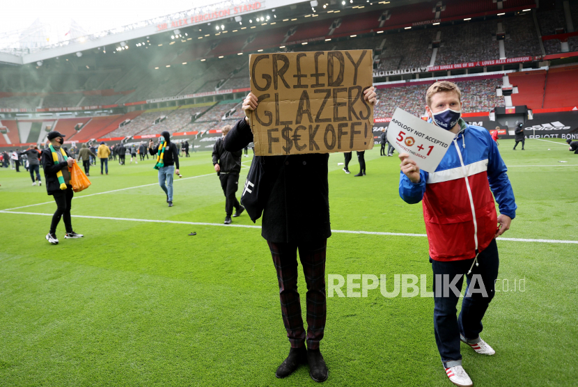 Soccer Football - Manchester United fans protest against their owners before the Manchester United v Liverpool Premier League match - Old Trafford, Manchester, Britain - May 2, 2021 Manchester United fans holding signs on the pitch in protest against their owners before the match Action Images via REUTERS/Carl Recine