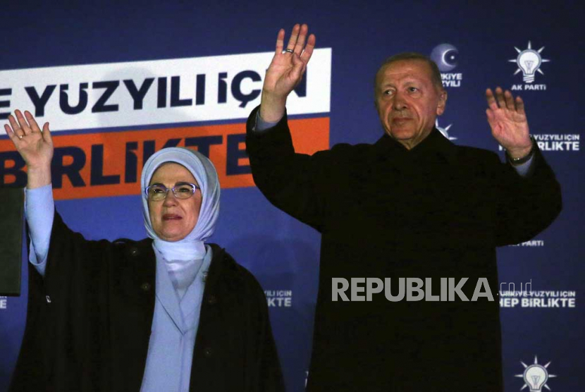  Presiden Turki Recep Tayyip Erdogan (kanan) dan istrinya Emine memberi isyarat kepada para pendukungnya di markas partai, di Ankara, Turki, Senin dini hari, (15/5/2023). Erdogan yang telah memerintah negaranya dengan cengkeraman yang semakin kokoh selama 20 tahun, adalah terkunci dalam perlombaan pemilihan yang ketat pada hari Minggu, dengan kemungkinan menang atau kalah melawan penantang utamanya saat suara terakhir dihitung.
