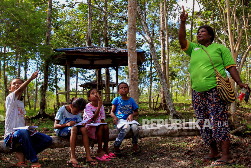 Guru mengajar sejumlah siswa di Sekolah Alam Kampung Rhepang Muaif, Distrik Nimbrokrang, Jayapura, Papua, Sabtu (3/6/2023). Sekolah yang menerapkan Kurikulum Merdeka Belajar itu bertujuan mendidik siswa untuk mengenal, mencintai, serta melestarkan alam sejak usia dini. ANTARA FOTO/Gusti Tanati/app/rwa.