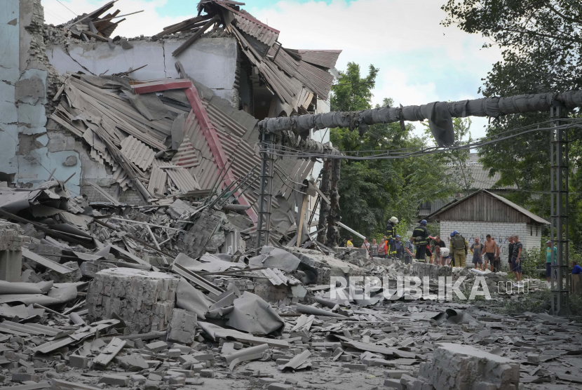 Petugas SAR dan penduduk setempat mengambil mayat dari bawah puing-puing sebuah bangunan setelah serangan udara Rusia di Lysychansk, wilayah Luhansk, Ukraina, Kamis, 16 Juni 2022.