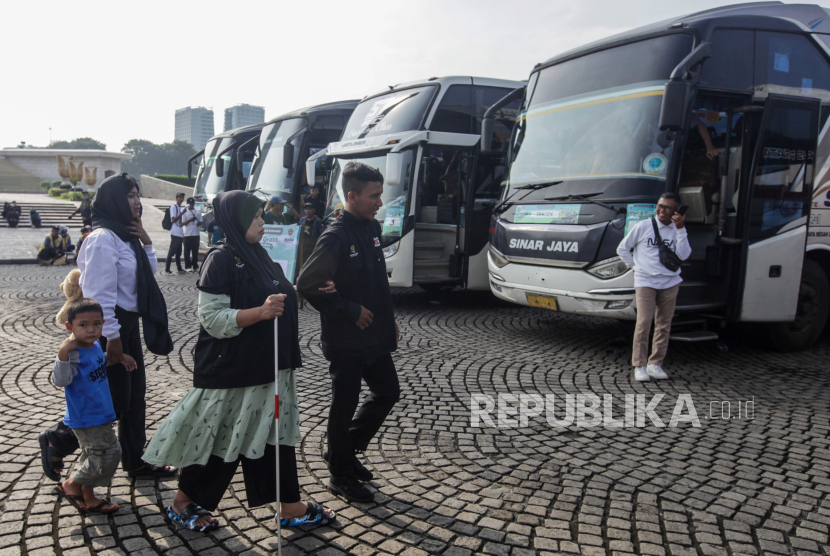 Peserta mudik gratis disabilitas dituntun menuju bus di Monumen Nasional, Jakarta, Kamis (4/4/2024). 