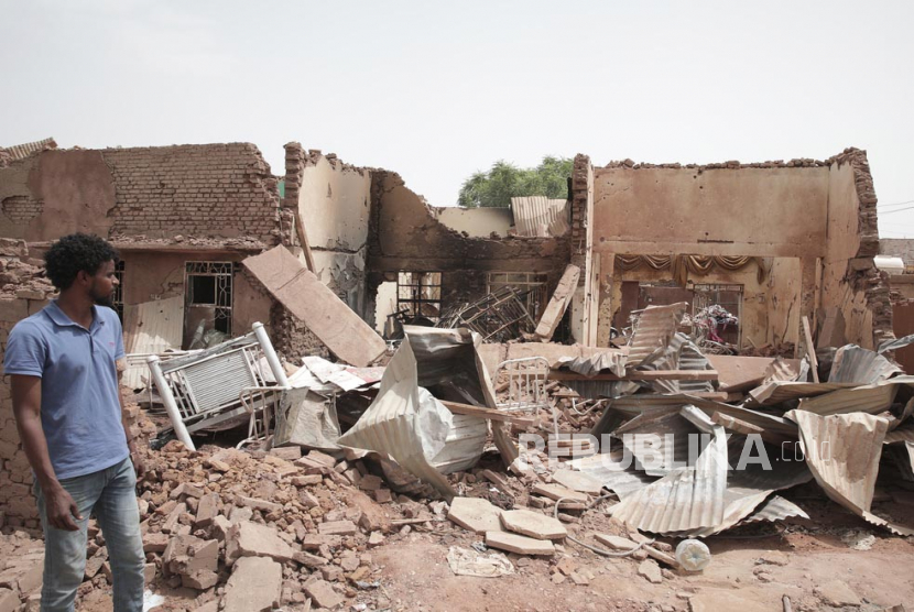  Seorang pria berjalan melewati sebuah rumah yang terkena serangan dalam pertempuran baru-baru ini di Khartoum, Sudan, Selasa (25/4/2023).