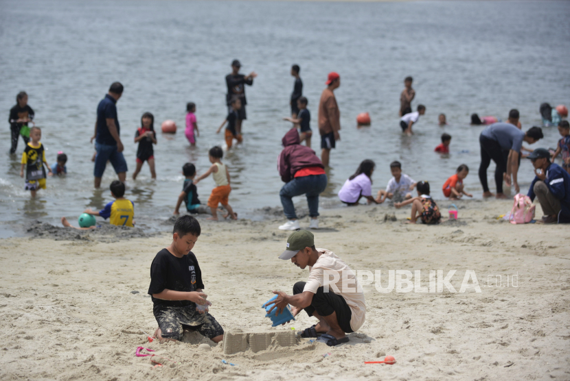 Sejumlah warga berwisata saat libur lebaran di Pantai Lagoon,   Ancol Taman Impian, Jakarta, Kamis (11/4/2024). 