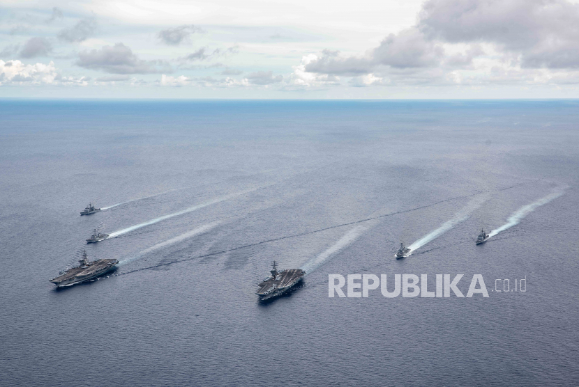 Sebuah foto selebaran yang disediakan oleh Kantor Informasi Angkatan Laut AS menunjukkan kapal induk USS Ronald Reagan (CVN 76) dan USS Nimitz (CVN 68) dan kelompok pemogokan mereka (CSGs) uap dalam formasi selama latihan di Laut Cina Selatan, 06 Juli 2020. Pada 13 Juli 2020, Menteri Luar Negeri AS Mike Pompeo secara resmi menolak sebagian besar klaim China atas Laut Cina Selatan. 