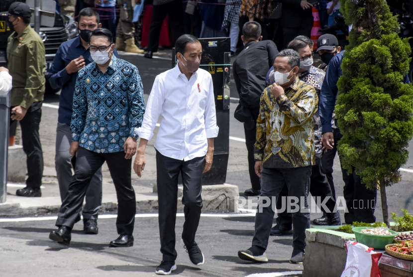 Presiden RI Joko Widodo (tengah) didampingi Gubernur Jawa Barat Ridwan Kamil (kiri) dan Plt Wali Kota Bandung Yana Mulyana (kanan) saat kunjungan kerja di Pasar Sederhana, Sukajadi, Kota Bandung, Senin (17/1/2022). Dalam kunjungan tersebut Presiden RI Joko Widodo membagikan 2.000 paket sembako serta menyalurkan Bantuan Tunai untuk Pedagang Kaki Lima dan Warung (BT-PKLW) sebesar Rp1,2 juta kepada sedikitnya 100 pedagang di pasar tersebut. Foto: Republika/Abdan Syakura