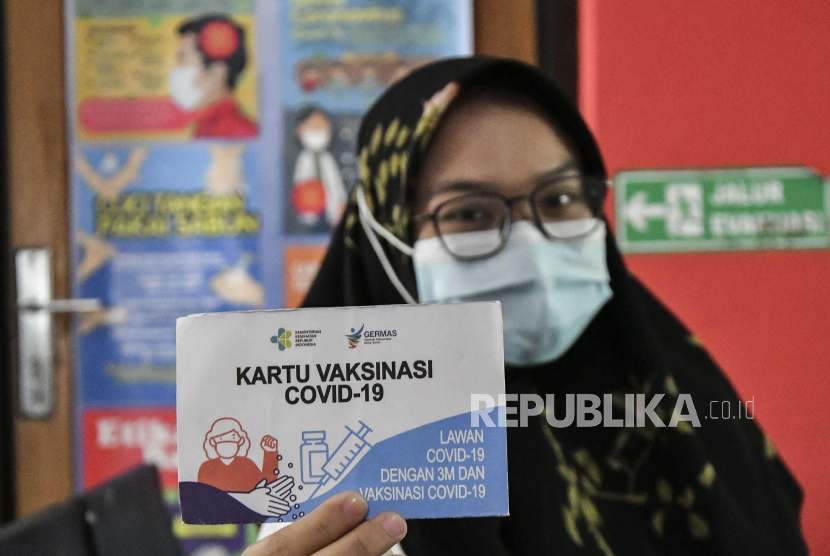 Seorang tenaga kesehatan menunjukan kartu vaksinasi COVID-19 di Puskesmas Sukamahi, Cikarang, Kabupaten Bekasi, Jawa Barat, Rabu (17/2/2021). Menurut data Dinas Kesehatan Kabupaten Bekasi, sebanyak 10.418 dari total 10.460 tenaga kesehatan telah menerima vaksinasi dosis kedua dan ditargetkan selesai pada akhir bulan Februari 2021. 