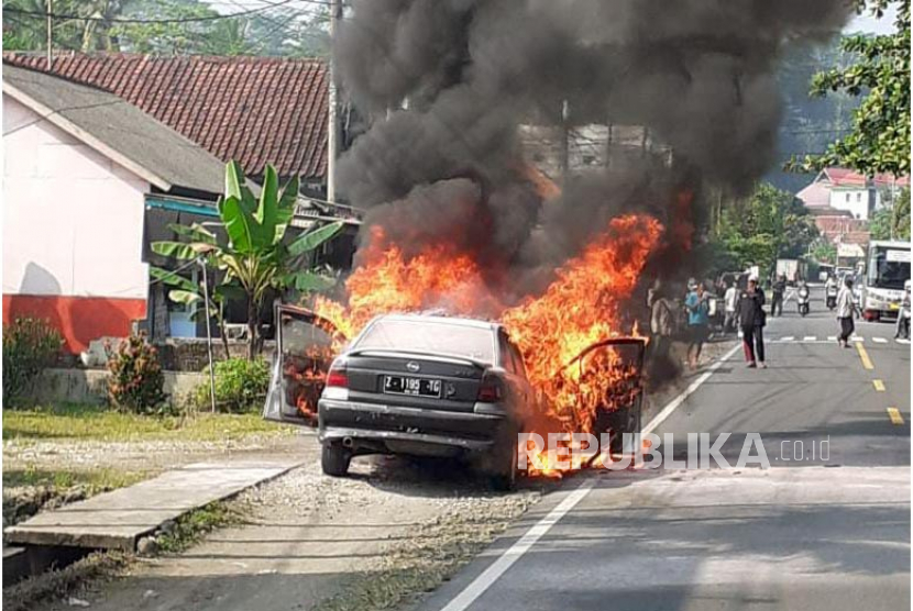 Sebuah mobil sedan terbakar di Jalan Raya Kalipucang, Kecamatan Kalipucang, Kabupaten Pangandaran, Jawa Barat, Senin (19/6/2023). 