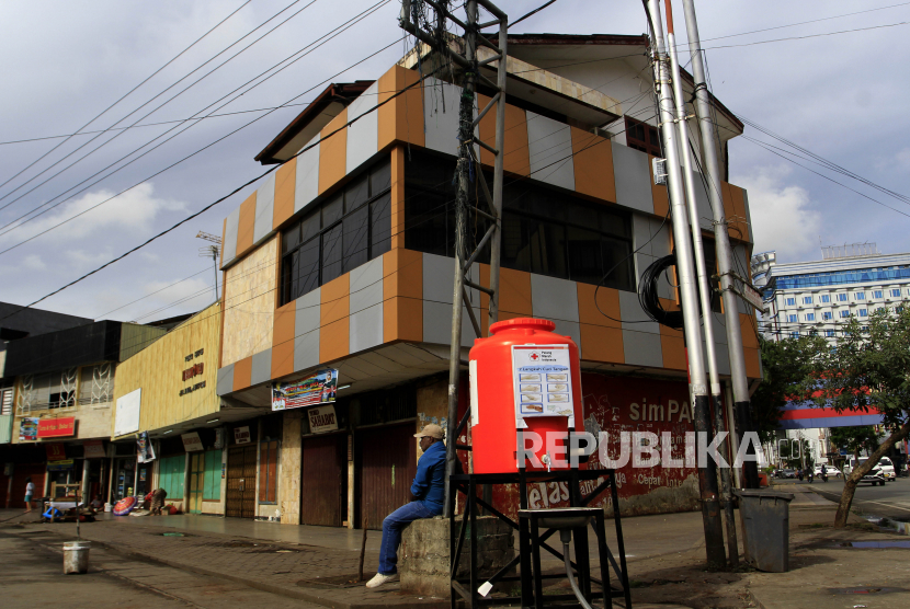 Seorang warga duduk di antara pertokoan yang tutup di  Jayapura, Papua. 4.356 pengemudi di Provinsi Papua yang terdampak penyebaran virus corona (COVID-19) menerima insentif Rp 600 ribu per orang dalam bentuk ATM dan tabungan bank BRI.