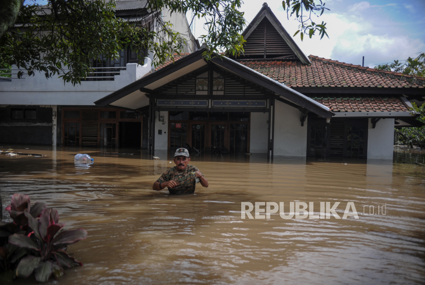 Seorang warga berada di depan rumah yang terendam air saat banjir melanda permukiman di Kelurahan Utama, Kecamatan Cimahi Selatan, Kota Cimahi, Jawa Barat. Warga di Dua Kecamatan Kota Cimahi membersihkan sisa material banjir.