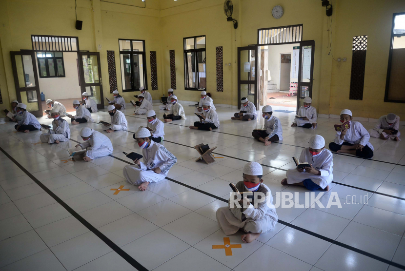 Sejumlah santri Ponpes Daarul Quran Al Kautsar Cibining Bogor Jawa ga melakukan kegiatan khataman Al Quran dengan menggunakan masker dan jaga jarak beberapa waktu lalu. 