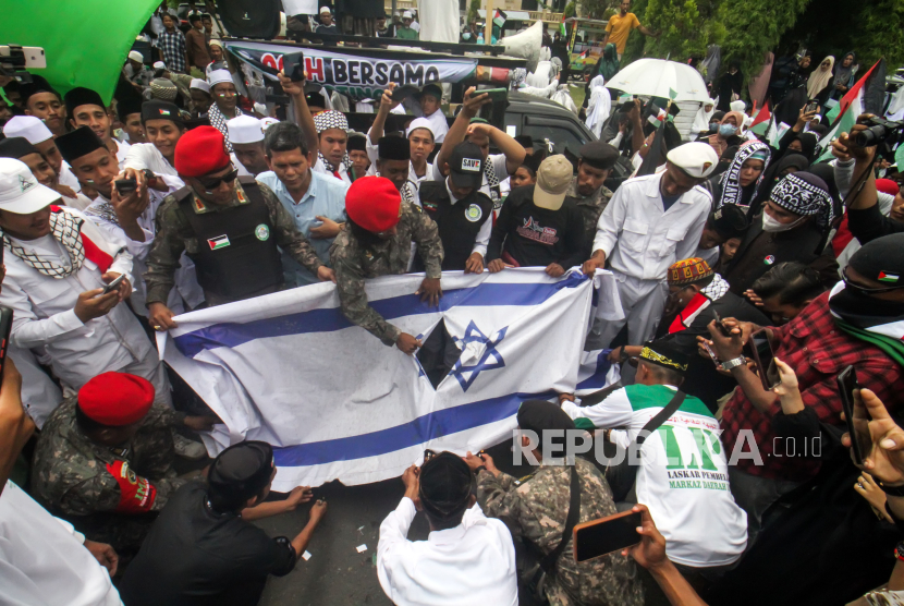 Sejumlah pengunjukrasa membakar bendera Israel dalam aksi kemanusiaan doa bersama Masyarakat Pase For Palestina di Lhokseumawe, Aceh, Selasa (14/11/2023). Aksi kemanusian tersebut untuk kemenangan dan kemerdekaan rakyat Palestina dari serangan Israel dan meminta dihentikannya serangan tersebut. 