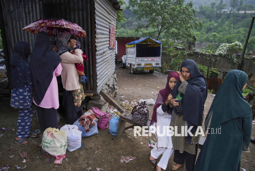 A group of Kashmiri villager women wait for transportation as they leave following overnight shelling from Pakistan at Gingal village in Uri district, Indian controlled Kashmir, Friday, May 9, 2025. 