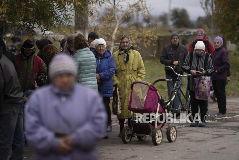 Orang-orang mengantre saat bantuan kemanusiaan didistribusikan di desa Mykhailo Lukasheve, di wilayah Zaporizhzhia, Ukraina, Kamis, 20 Oktober 2022.