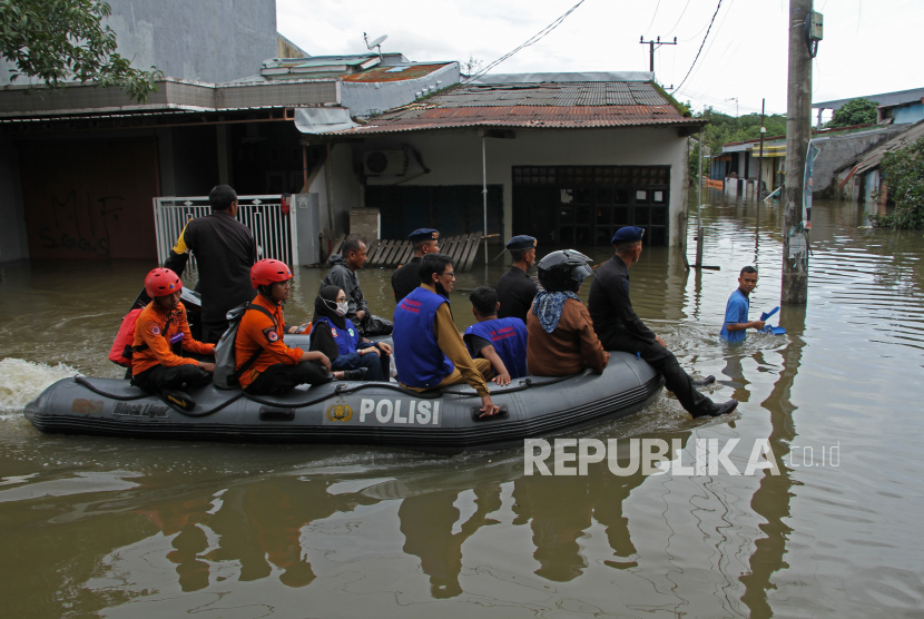 Polisi dan relawan melakukan patroli menggunakan perahu karet melewati banjir di Perumnas Antang, Makassar, Sulawesi Selatan. BNPB sebut banjir di Kota Makassar menyebabkan sebanyak 1.869 jiwa mengungsi.