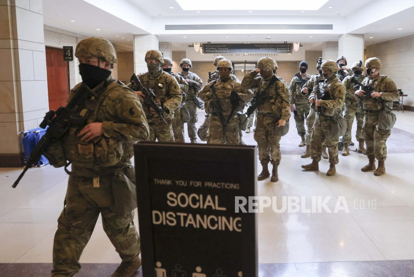  Pasukan Garda Nasional berjalan di Pusat Pengunjung Capitol AS selama gladi resik untuk upacara pelantikan Presiden terpilih Joe Biden, di Capitol di Washington, Senin, 18 Januari 2021.