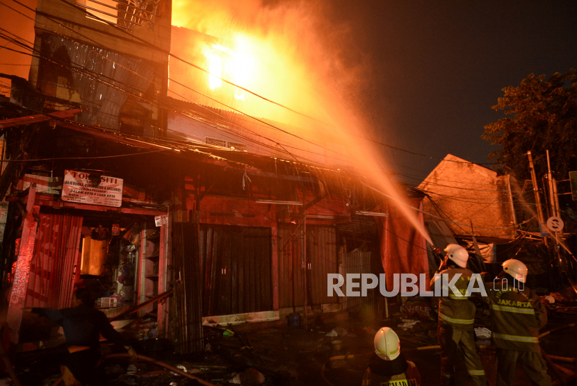 Petugas berusaha memadamkan kebakaran yang terjadi di Pasar Gembrong, Jakarta Timur, Ahad (25/4/2022). Sebanyak 400 bangunan yang terdiri dari rumah dan pertokoan, ludes terbakar di Pasar Gembrong, Jakarta Timur, Ahad (24/4/2022) malam.